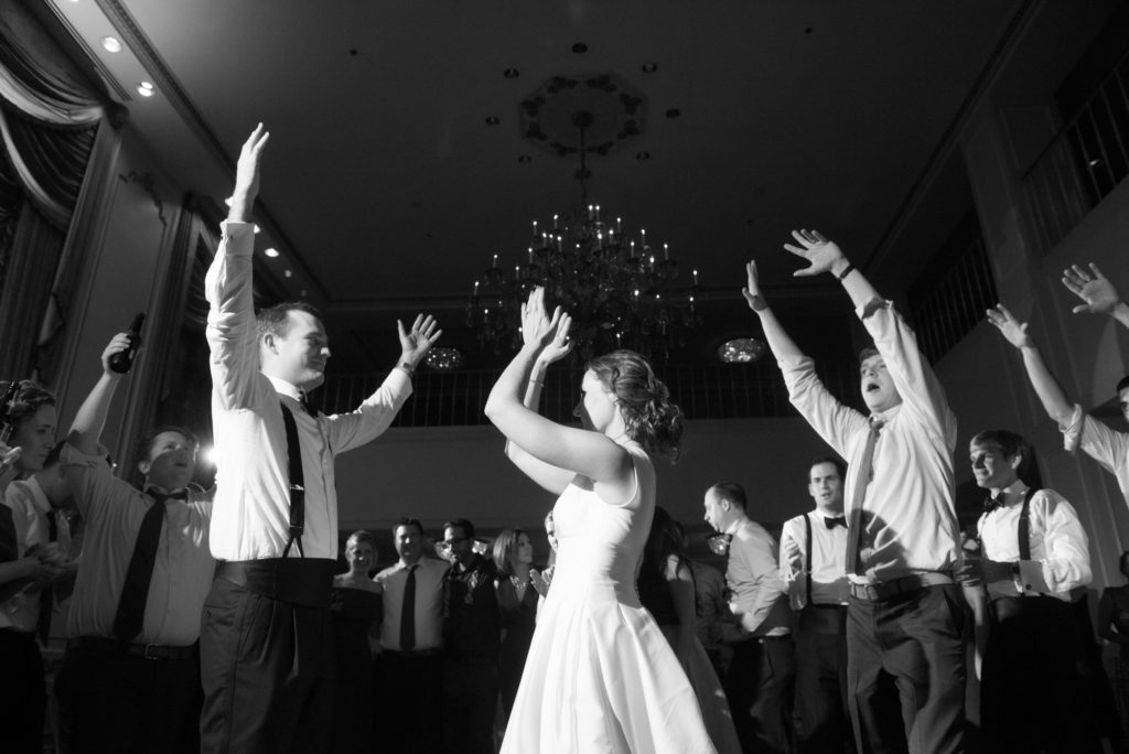 black and white wedding photograph of bride and groom partying on dance floor