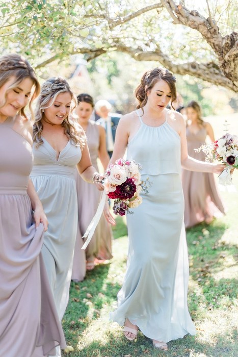 bridesmaids candidly photographed walking under apple tree